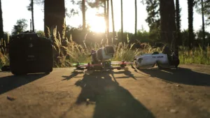 Rádio controle, drone FPV de 5 polegadas e óculos FPV lado a lado ao pôr do sol